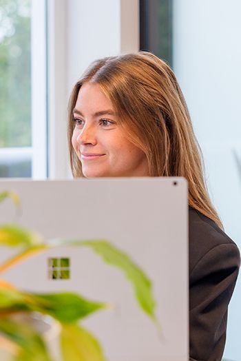 Medewerker achter een laptop kijkt geconcentreerd, met een focus op duurzame oplossingen zoals het Digitaal Product Paspoort.